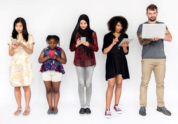 Pessoas de diferentes raças, etnias, cultura e idade utilizando telas digitais.
