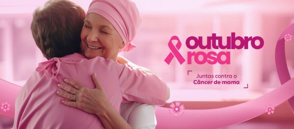 Banner rosa no qual 2 mulheres se abraçam afetivamente. Uma usando um lenço rosa na cabeça, a outra, uma blusa rosa. No mesmo, encontra-se a seguinte frase: Outubro Rosa / Juntas contra o câncer de mama.