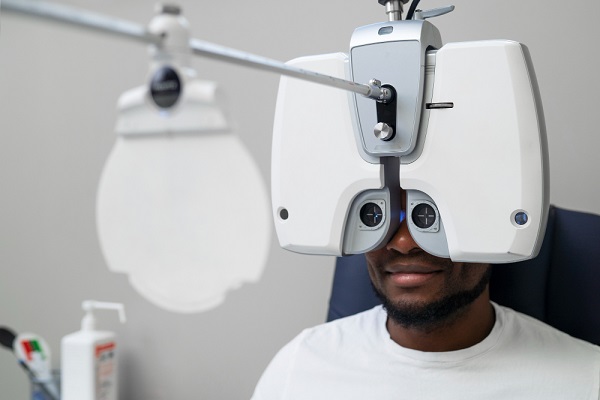 Homem negro, jovem, fazendo exame oftalmológico.