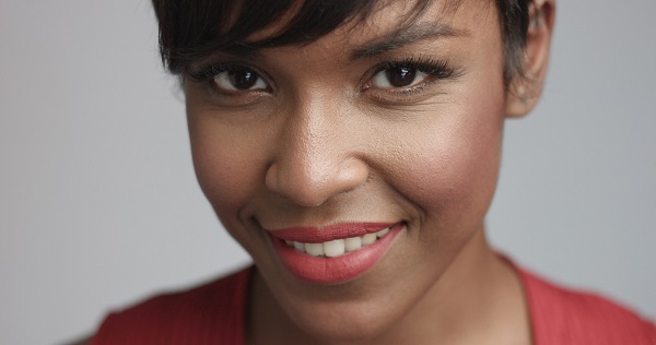 Linda mulher negra sorri feliz para a câmera.